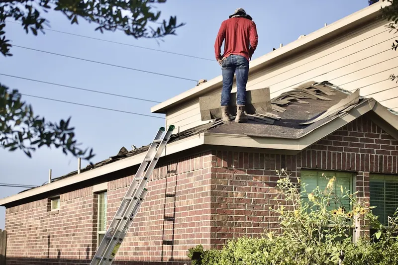 Professional roofer working on a residential roof in Da Costa